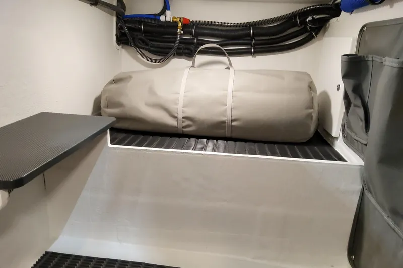 Slide: The Image of Storage compartment in 2026 Formula 330 Crossover Bowrider OB with a rolled-up cover. - 37