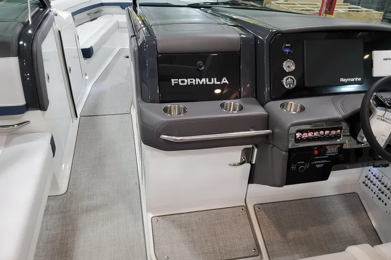 Slide: The Image of 2026 Formula 330 Crossover Bowrider OB cockpit with Raymarine display and cup holders. - 56