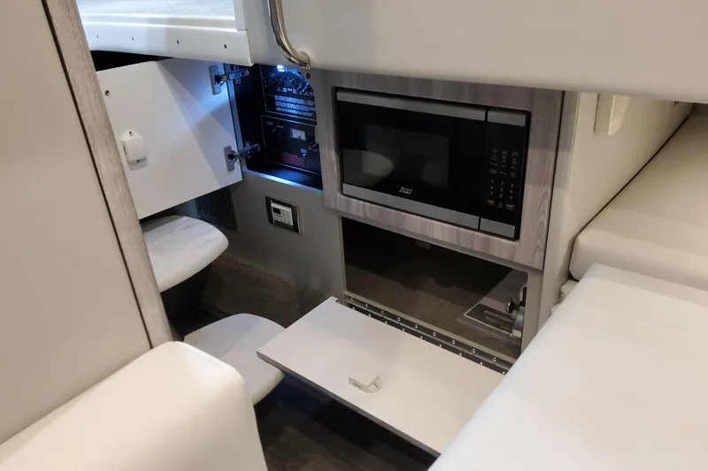 Slide: The Image of Interior of 2026 Formula 330 Crossover Bowrider OB with microwave and storage compartments. - 63