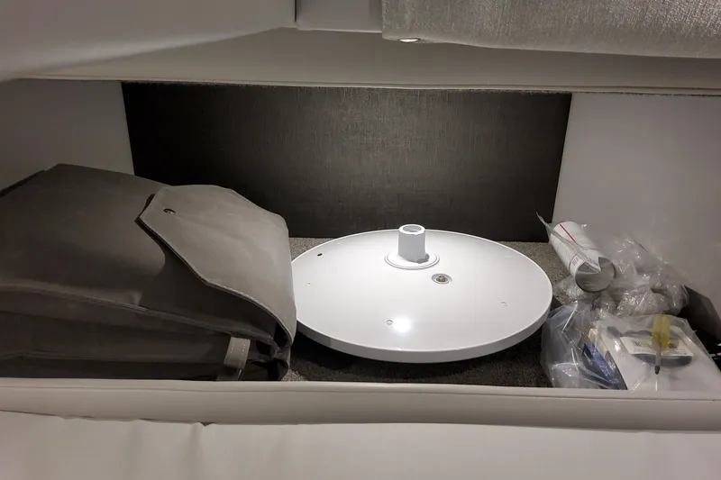 Slide: The Image of Storage compartment in 2026 Formula 330 Crossover Bowrider OB with various items. - 69