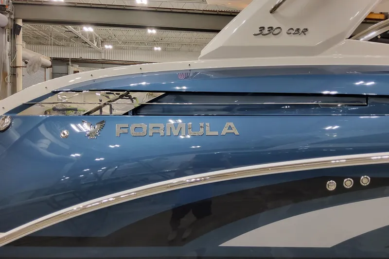 Slide: The Image of 2026 Formula 330 Crossover Bowrider OB, blue exterior, indoor showroom display. - 8