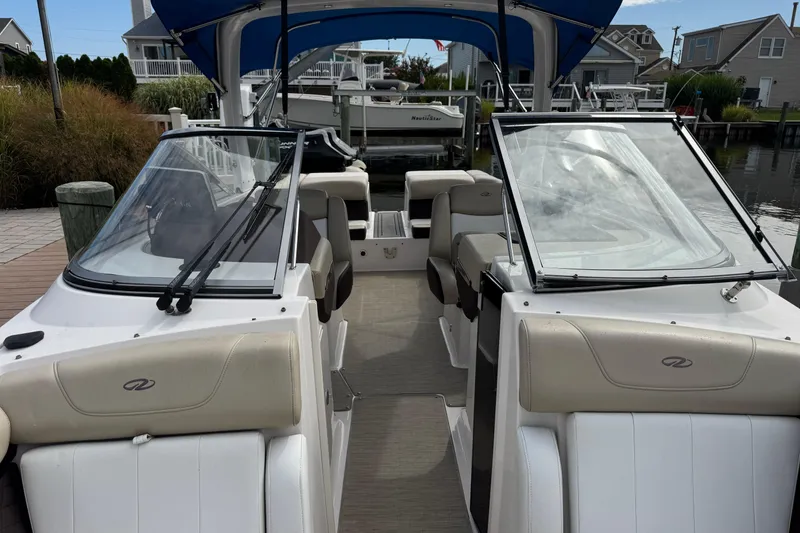 Slide: The Image of 2015 Regal 2700 Bowrider boat with open seating, docked in a marina. - 11