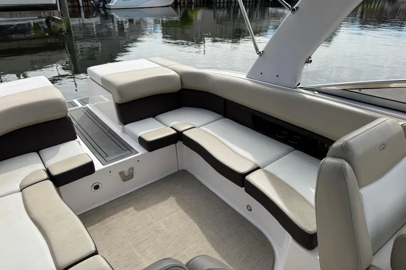 Slide: The Image of 2015 Regal 2700 Bowrider interior with beige and black seating, docked by the water. - 14