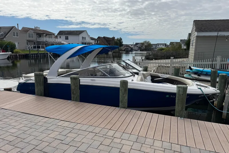 Slide: The Image of 2015 Regal 2700 Bowrider boat docked in a residential canal setting. - 28