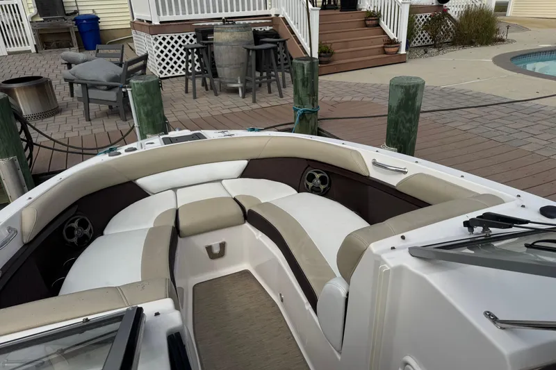 Slide: The Image of 2015 Regal 2700 Bowrider boat interior with beige seating at dockside. - 9