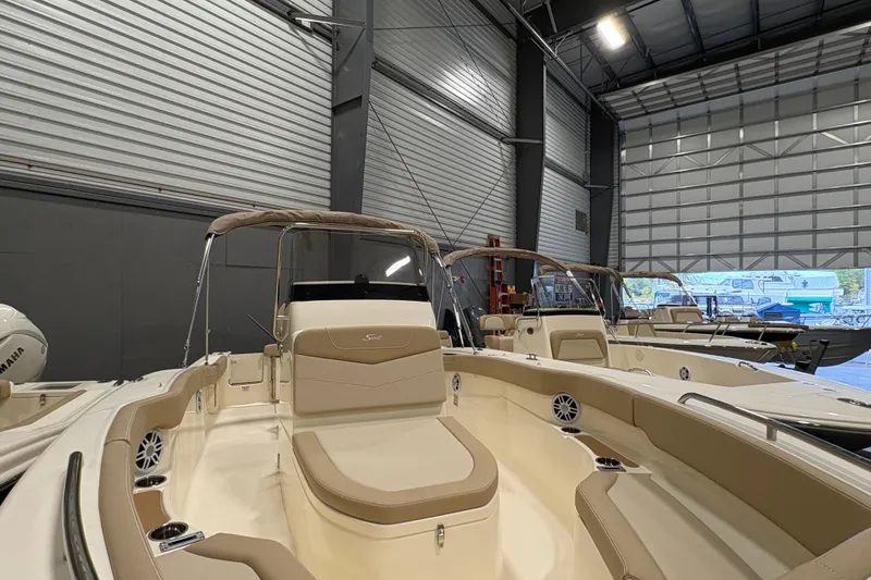 Slide: The Image of 2025 Scout 215 XSF boat in a showroom, featuring sleek design and comfortable seating. - 10