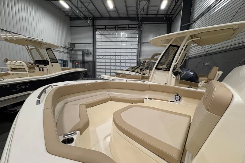 Slide: The Image of 2025 Scout 215 XSF boat interior in a showroom, featuring beige seating and modern design. - 11