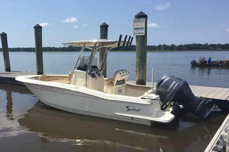 Slide: The Image of Manufacturer Provided Image: 2025 Scout 215 XSF boat docked by the water on a sunny day. - 15