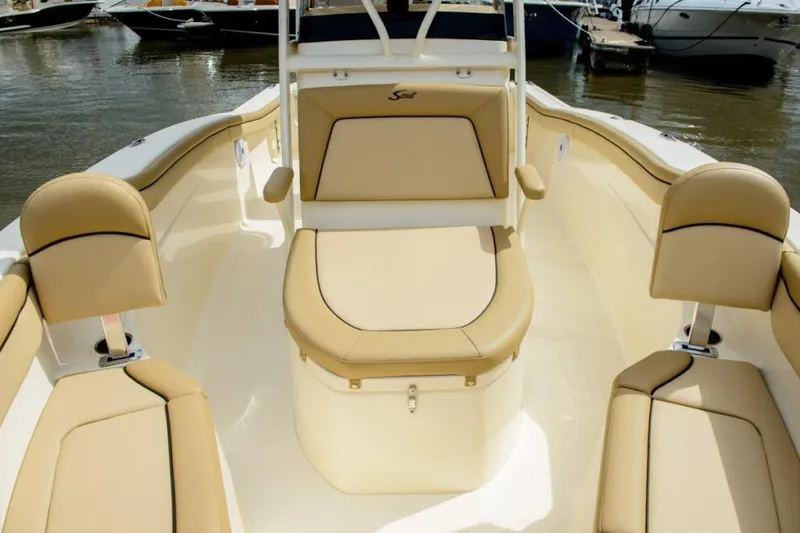 Slide: The Image of Manufacturer Provided Image: 2025 Scout 215 XSF boat interior with beige seating, docked on calm water. - 20