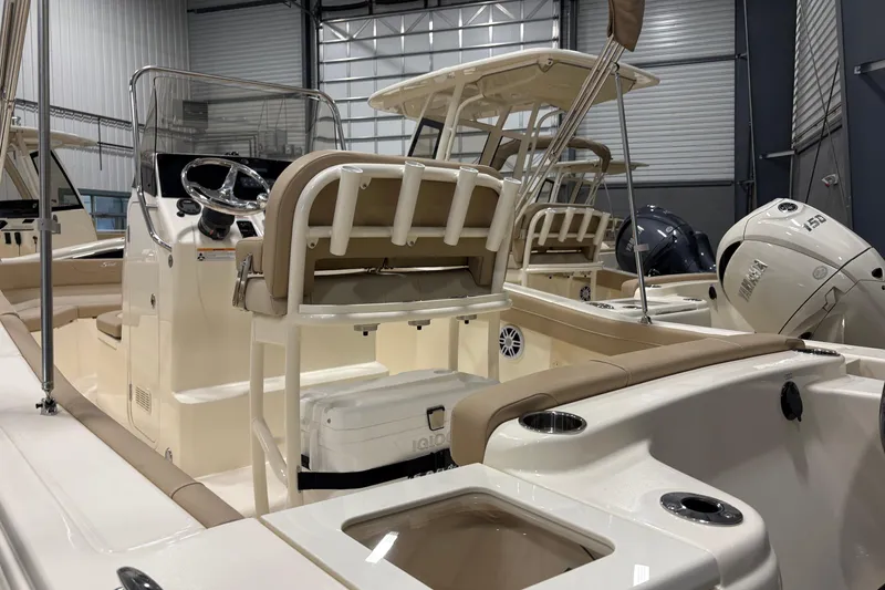 Slide: The Image of 2025 Scout 215 XSF boat interior with seating and controls in a showroom. - 7
