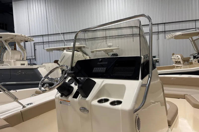 Slide: The Image of 2025 Scout 215 XSF boat interior with steering wheel and console in showroom. - 8