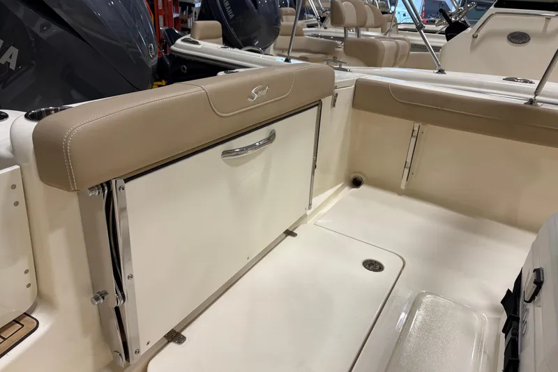 Slide: The Image of 2025 Scout 215 XSF boat interior with beige seating and storage compartment. - 9