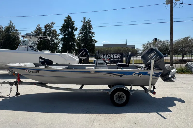 Slide: The Image of 2009 G3 1860 CC boat on trailer with Yamaha outboard motor, parked outdoors. - 12
