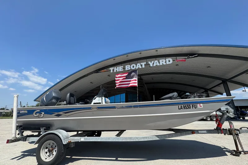 Slide: The Image of 2009 G3 1860 CC boat on trailer at The Boat Yard, American flag displayed. - 2