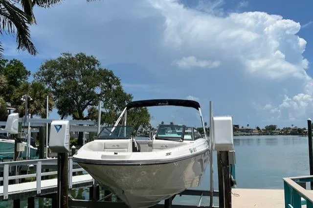 The Image of 2020 Sea Ray SPX 230 boat docked by a serene waterfront under a blue sky. - 0
