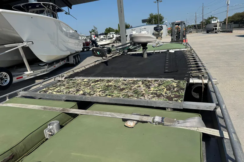Slide: The Image of Hanko 19 SC boat, 2013 model, with camouflage and green seating, parked outdoors. - 11