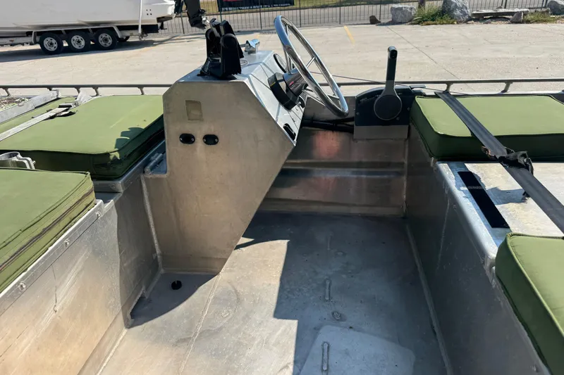 Slide: The Image of Interior of a 2013 Hanko 19 SC boat with green cushioned seats and steering console. - 18