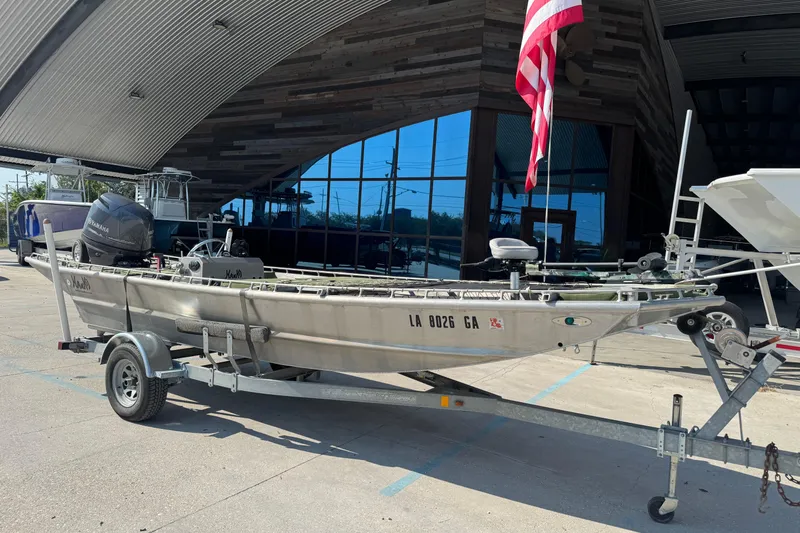 Slide: The Image of 2013 Hanko 19 SC boat on trailer, parked outside modern building with American flag. - 3
