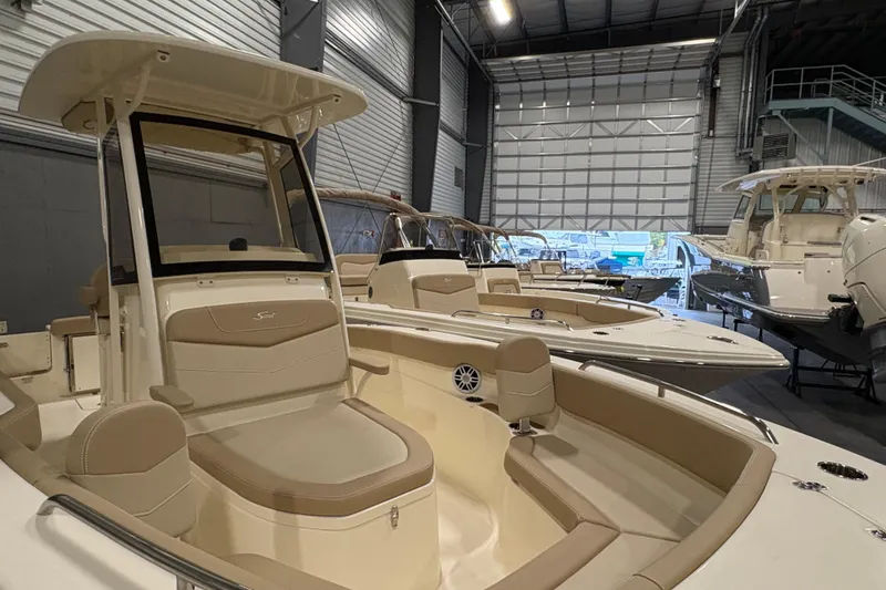 Slide: The Image of 2025 Scout 215 XSF boat displayed in a showroom with other boats. - 10