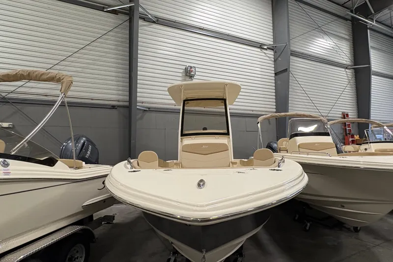 Slide: The Image of 2025 Scout 215 XSF boat displayed in a showroom with other boats. - 2