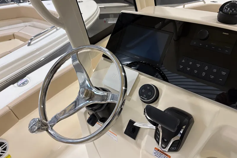 Slide: The Image of 2025 Scout 215 XSF boat helm with steering wheel and control panel. - 7
