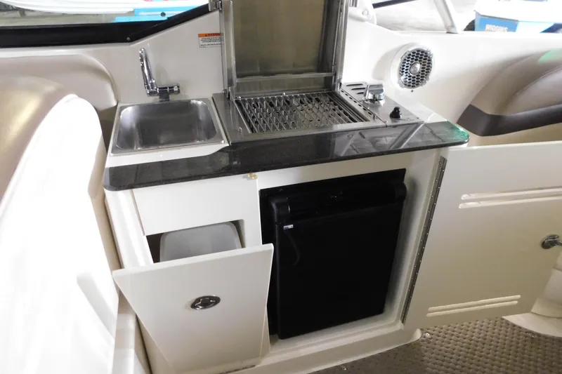 Slide: The Image of 2012 Sea Ray 300 SLX boat kitchenette with sink, grill, and mini fridge. - 17