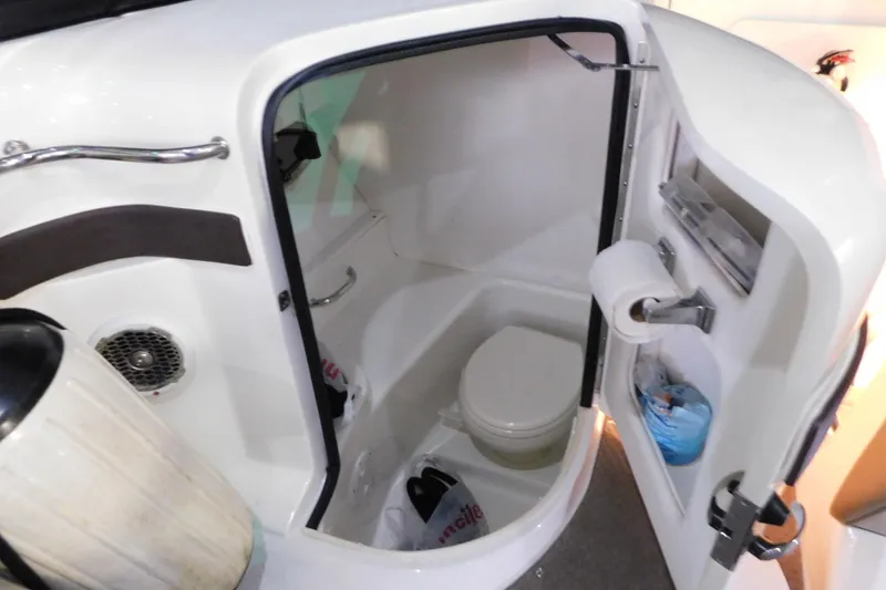 Slide: The Image of 2012 Sea Ray 300 SLX boat bathroom with toilet and storage compartments. - 20