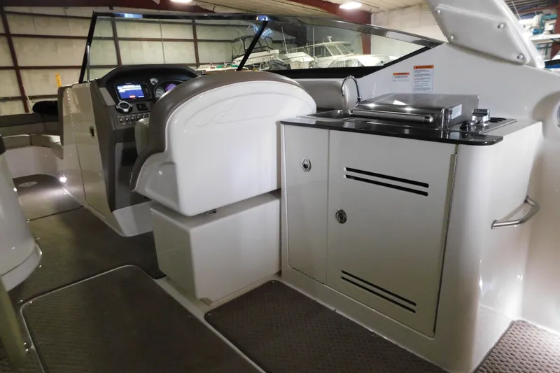 Slide: The Image of 2012 Sea Ray 300 SLX boat interior with helm and kitchenette area. - 38
