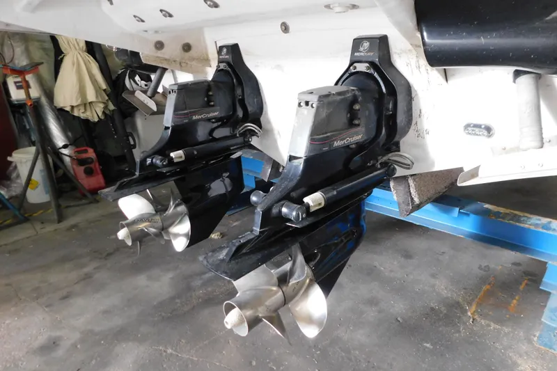 Slide: The Image of 2012 Sea Ray 300 SLX with dual MerCruiser outdrives in a workshop setting. - 47