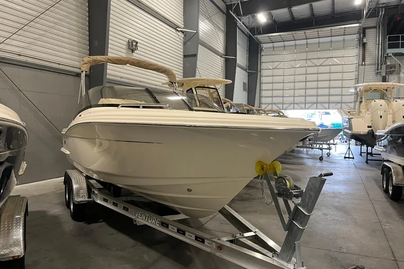 The Image of 2025 Scout 215 Dorado boat on trailer in indoor storage facility. - 0