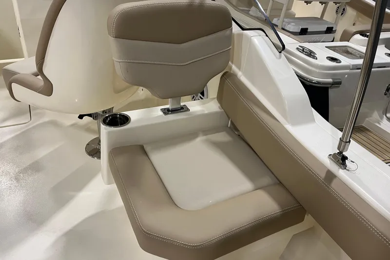 Slide: The Image of 2025 Scout 215 Dorado boat interior with beige seating and cup holder. - 10