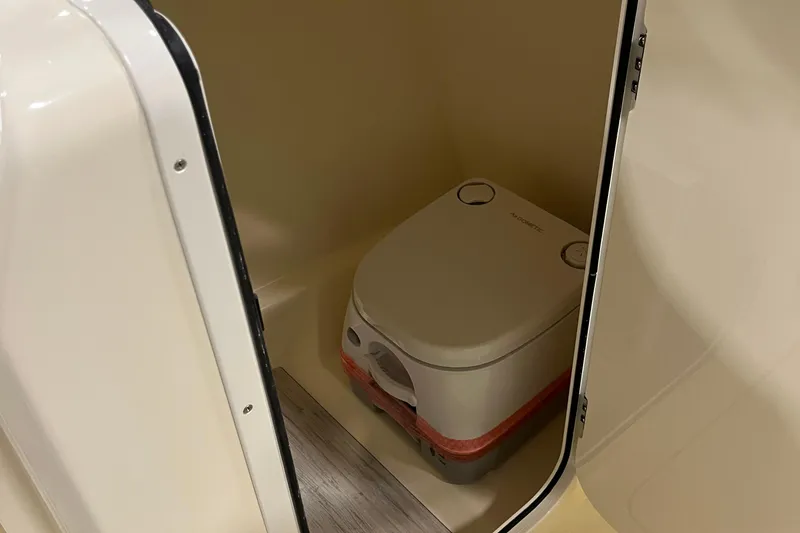 Slide: The Image of Portable toilet inside 2025 Scout 215 Dorado boat compartment. - 15