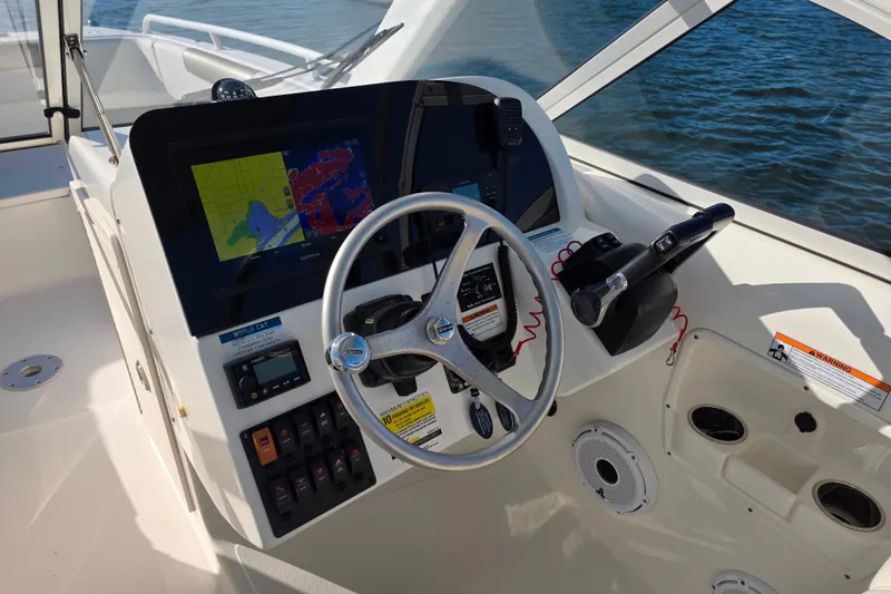 Slide: The Image of 2022 World Cat 255 DC helm with navigation display and steering wheel. - 12