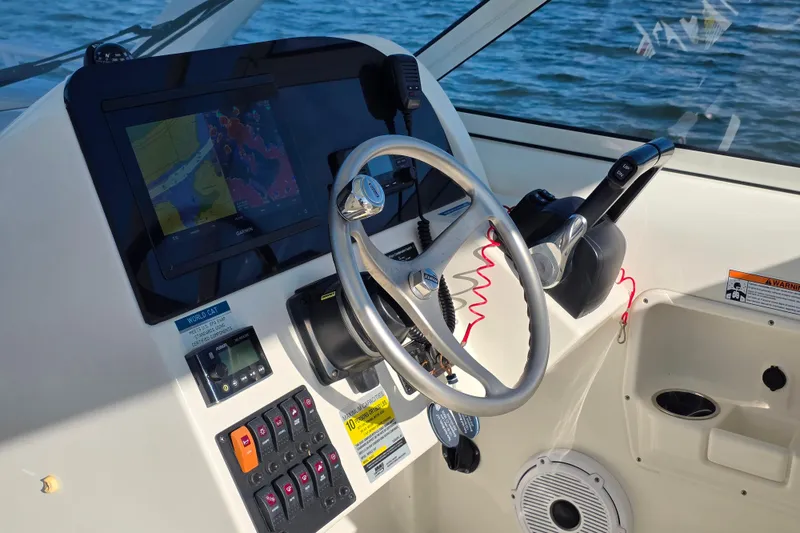 Slide: The Image of 2022 World Cat 255 DC boat dashboard with steering wheel and navigation system. - 13