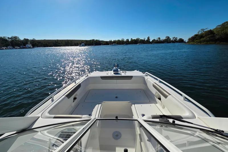 Slide: The Image of 2022 World Cat 255 DC boat on a sunny lake, showcasing spacious seating and clear blue water. - 18