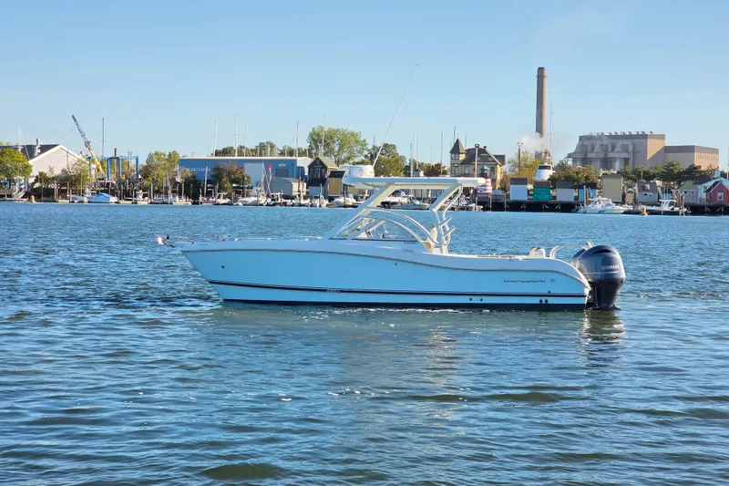 Slide: The Image of 2022 World Cat 255 DC boat on calm water near a marina. - 23