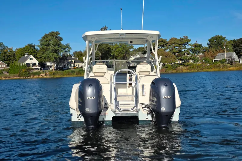 Slide: The Image of 2022 World Cat 255 DC boat with dual Yamaha 150 engines on a serene lake. - 3