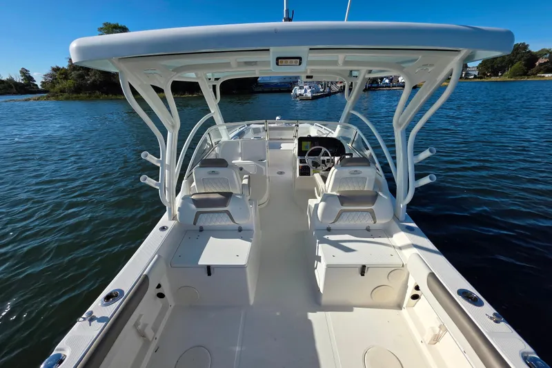 Slide: The Image of 2022 World Cat 255 DC boat on calm water, featuring dual consoles and spacious seating. - 4