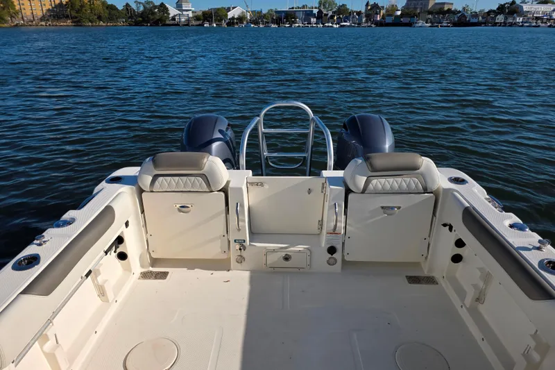Slide: The Image of 2022 World Cat 255 DC boat interior with dual engines on a calm lake. - 6