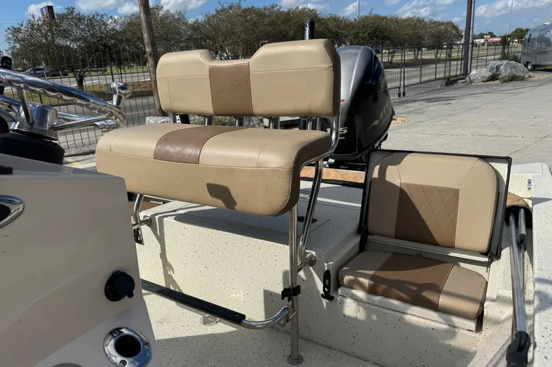 Slide: The Image of 2020 Xpress H20B Bay boat seats, beige upholstery, outdoor setting. - 13
