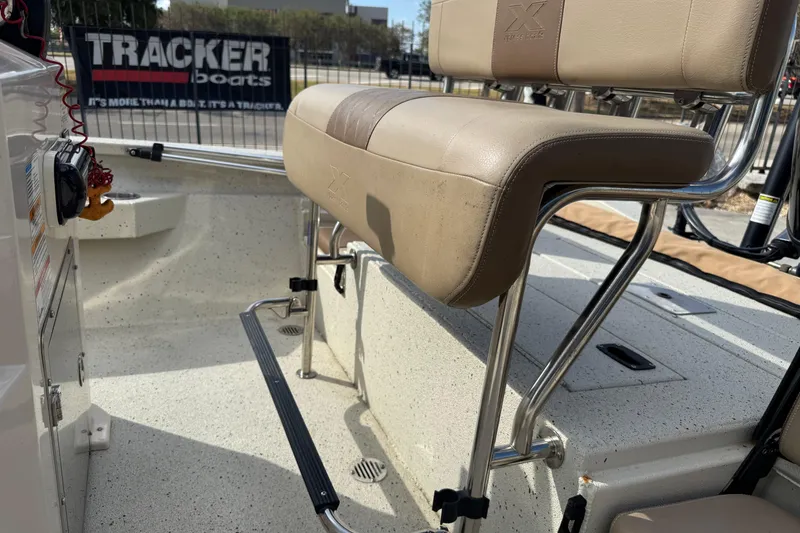 Slide: The Image of 2020 Xpress H20B Bay boat interior with beige seating and Tracker Boats sign. - 15