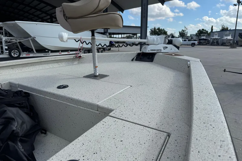 Slide: The Image of 2020 Xpress H20B Bay boat with Minn Kota trolling motor in a marina setting. - 18