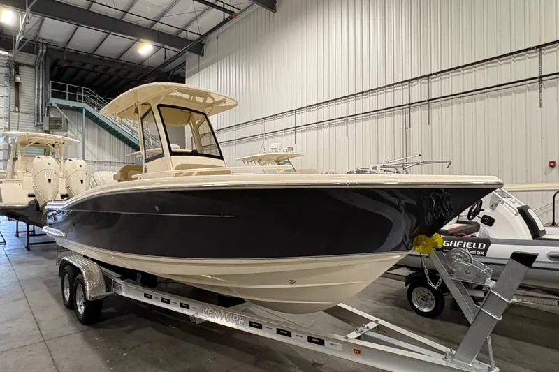 The Image of 2025 Scout 240 XSF boat on trailer in indoor showroom. - 0