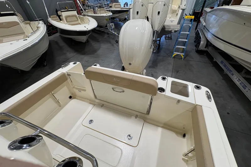 Slide: The Image of 2025 Scout 240 XSF boat interior with seating and motor in showroom. - 6