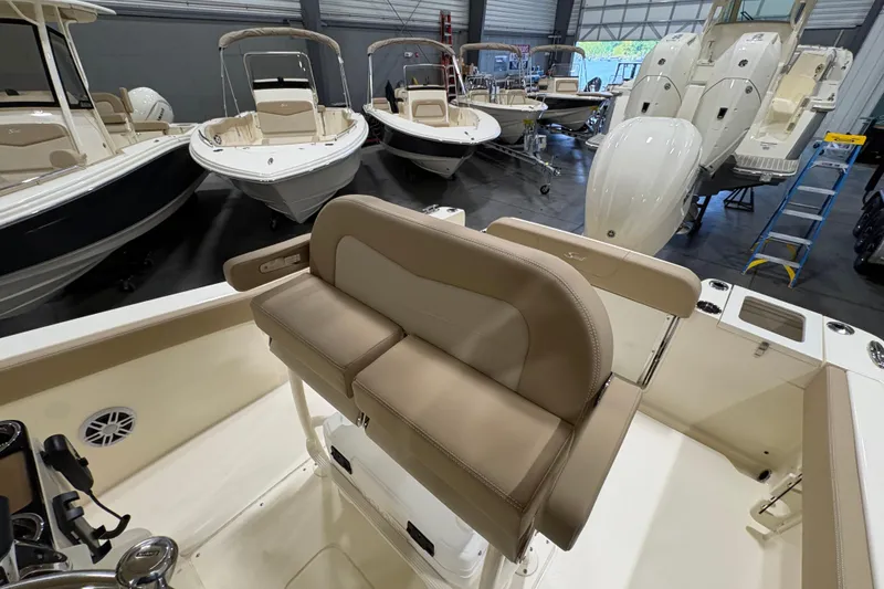 Slide: The Image of 2025 Scout 240 XSF boat interior with beige seating in a showroom. - 7