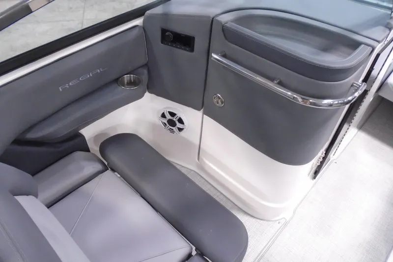 Slide: The Image of 2026 Regal LX4 boat interior with gray seating, cup holder, and speaker. - 16