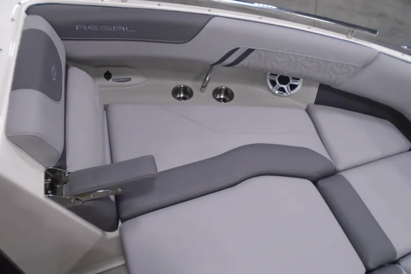 Slide: The Image of 2026 Regal LX4 boat interior with gray seating, cup holders, and speaker. - 19