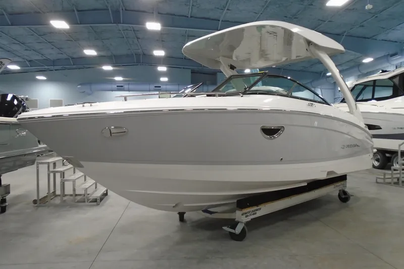 Slide: The Image of 2026 Regal LX4 boat in showroom, sleek design, white exterior, modern features. - 2