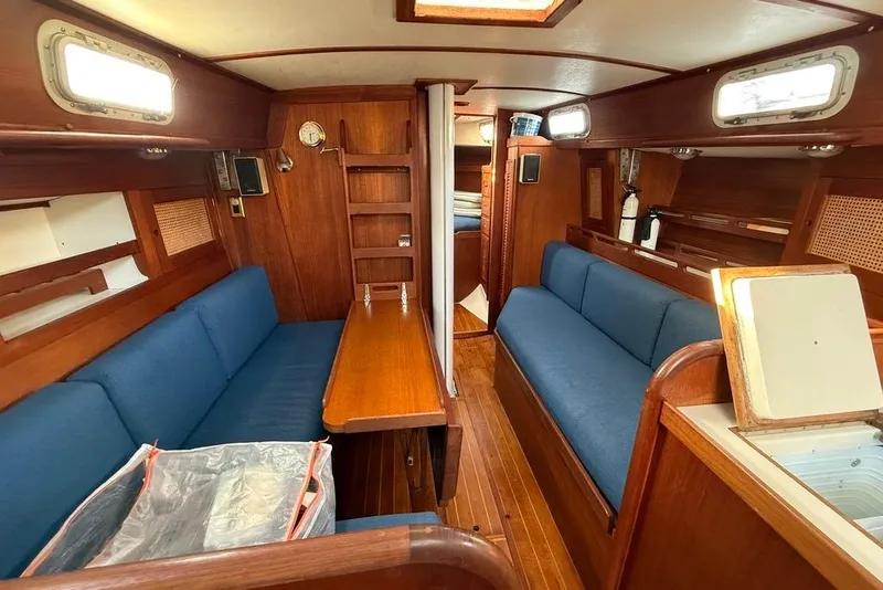 Slide: The Image of Interior of 1986 Tartan 37' sailboat with blue seating and wooden finishes. - 15
