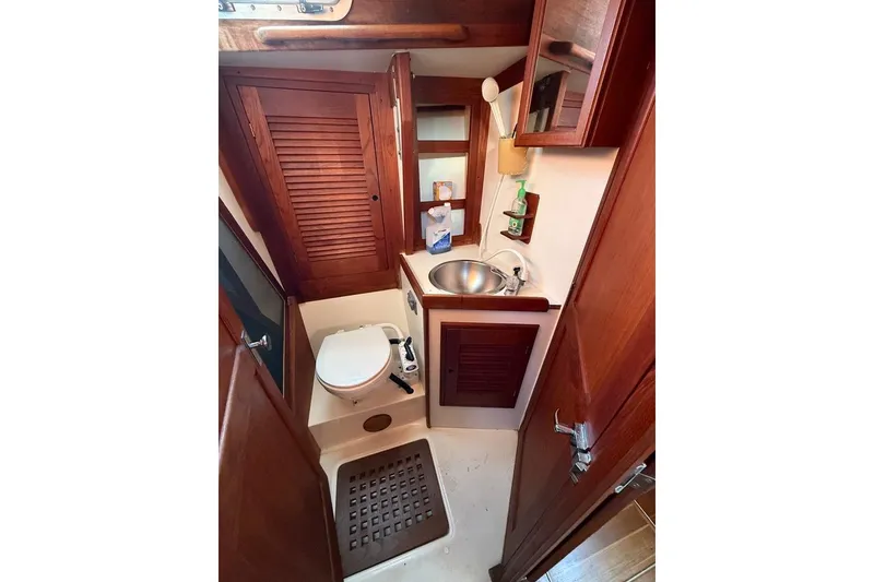 Slide: The Image of 1986 Tartan 37' yacht bathroom with wooden cabinets, sink, and toilet. - 26